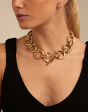 gold-plated metal necklace with large round and triangle-shaped Glow